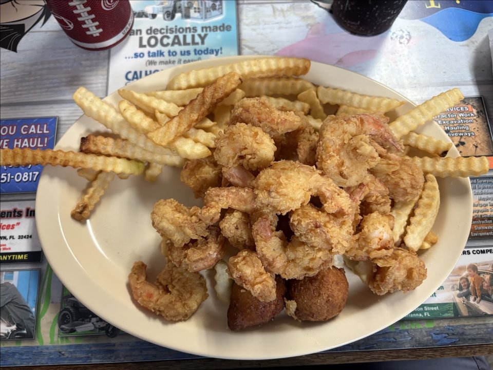 A seafood platter with hush puppies and sides.